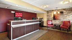 A reception area with a counter, free Wi-Fi sign, and a Red Roof Inn sign. - Red Roof Inn Charleston - Kanawha City, WV (Charleston)