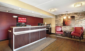 A reception area with a counter, free Wi-Fi sign, and a Red Roof Inn sign. - Red Roof Inn Charleston - Kanawha City, WV (Charleston)