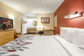 A hotel room with a bed, a desk, a chair, a television, and a bathroom. - Red Roof Inn Charleston - Kanawha City, WV (Charleston)