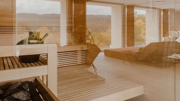 A modern interior with a wooden floor, a sofa, a chair, and a table. - Mercure Annecy Sud (Annecy)