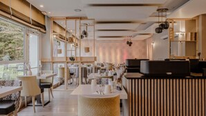 A modern restaurant with wooden accents, a bar area, and a view of trees outside. - Mercure Annecy Sud (Annecy)