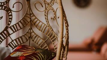 A wicker chair with a decorative backrest and a cushion with a floral pattern.