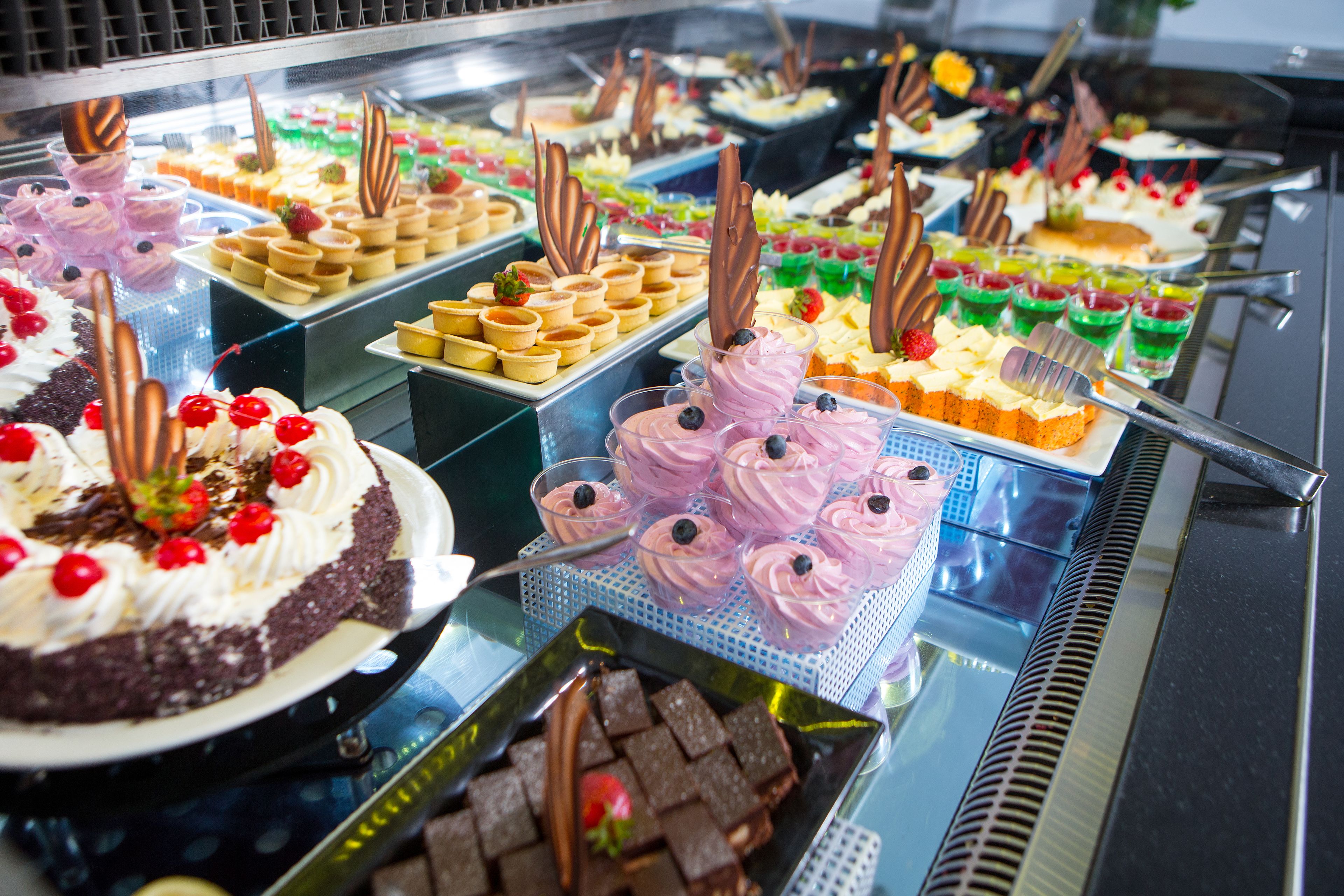 A buffet with various desserts including cakes, tarts, and pastries.