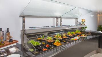 A buffet with various food options and condiments.