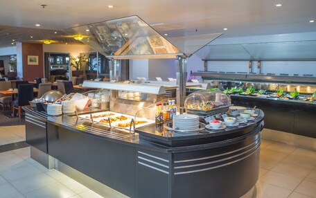A buffet area with various food stations, including a salad bar and a hot food section.