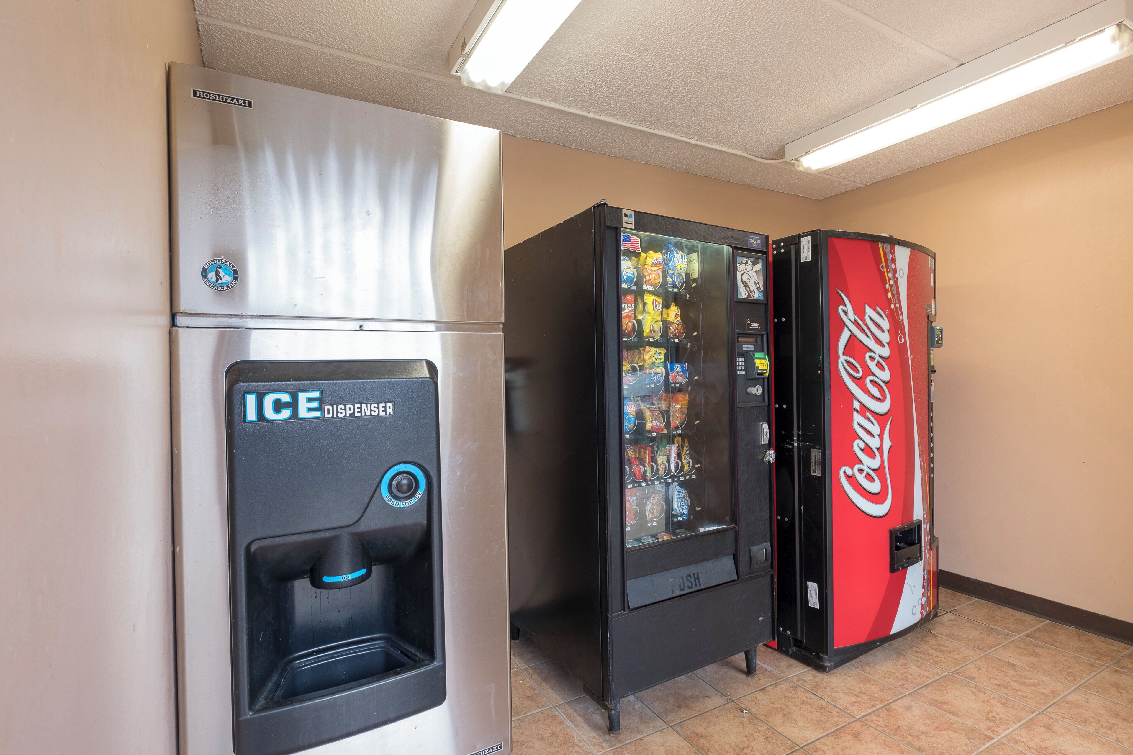 Zona de máquinas expendedoras con dispensador de hielo y máquina de Coca-Cola.