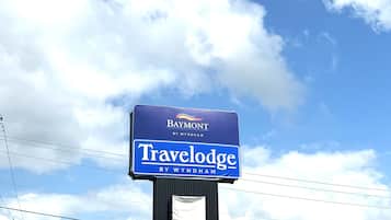 Señal de Travelodge con una vista despejada del cielo y nubes.