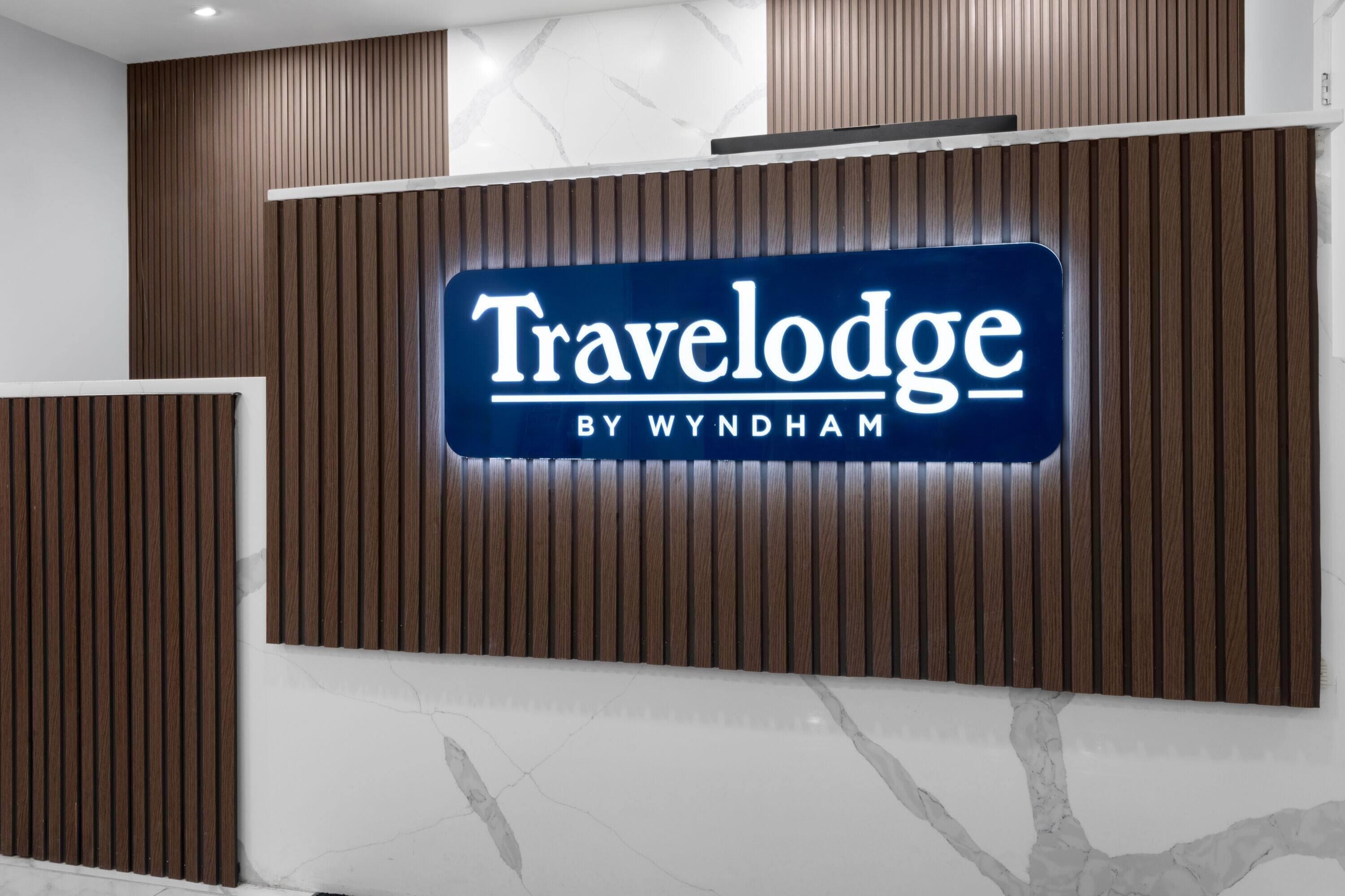 Un área de recepción con un letrero que dice "Travelodge by Wyndham".