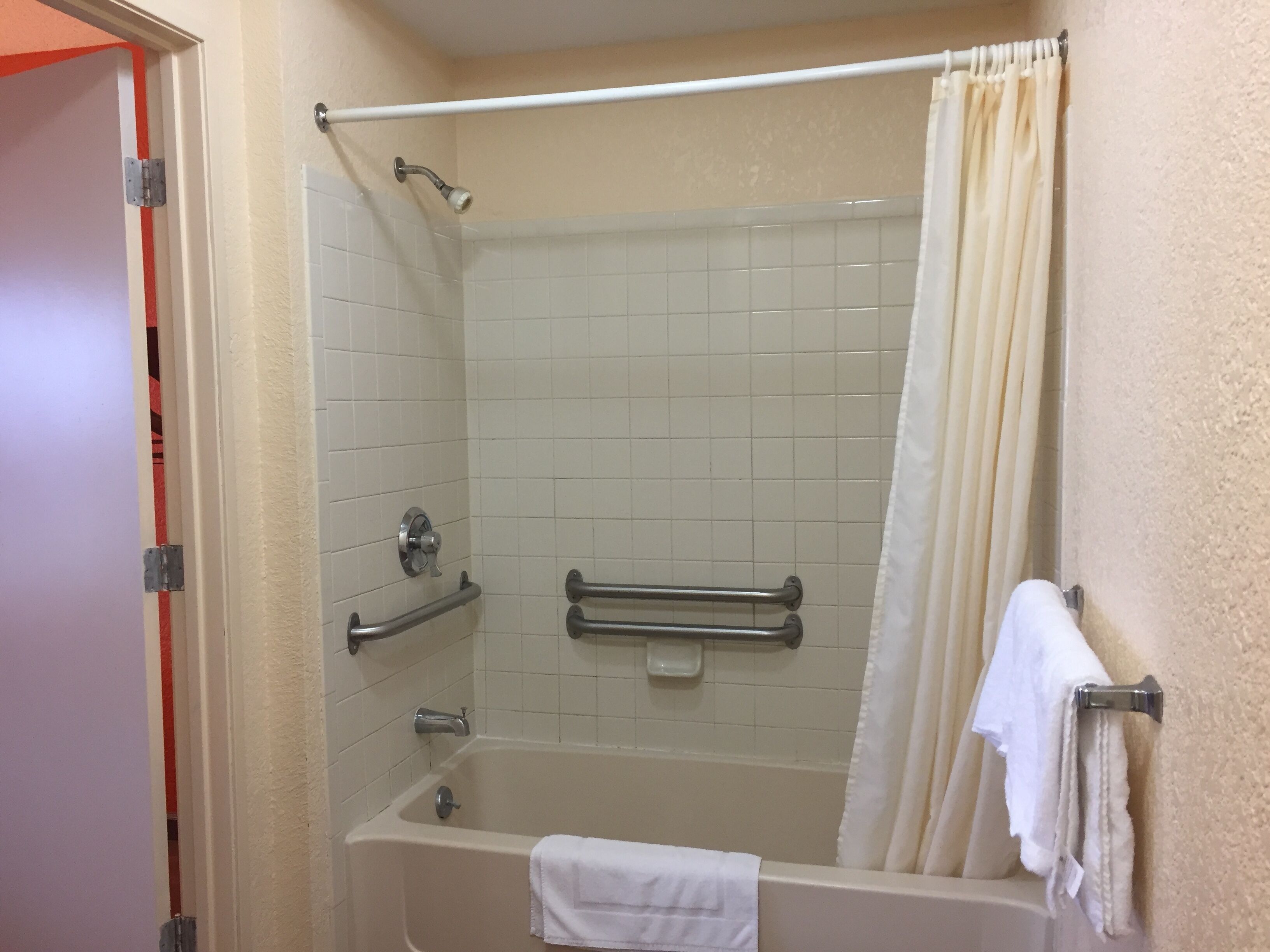 A standard bathroom with a bathtub, a shower, and a toilet.