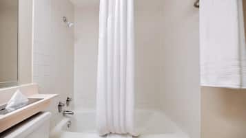 A bathroom with a bathtub, a towel rack, and a mirror.