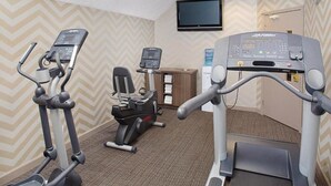 A hotel gym with treadmills, a stationary bike, and a water dispenser.