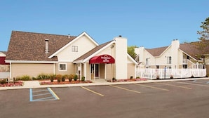 A Marriott hotel with a parking lot and a red awning.