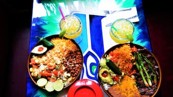 Two plates of food with drinks on a table.