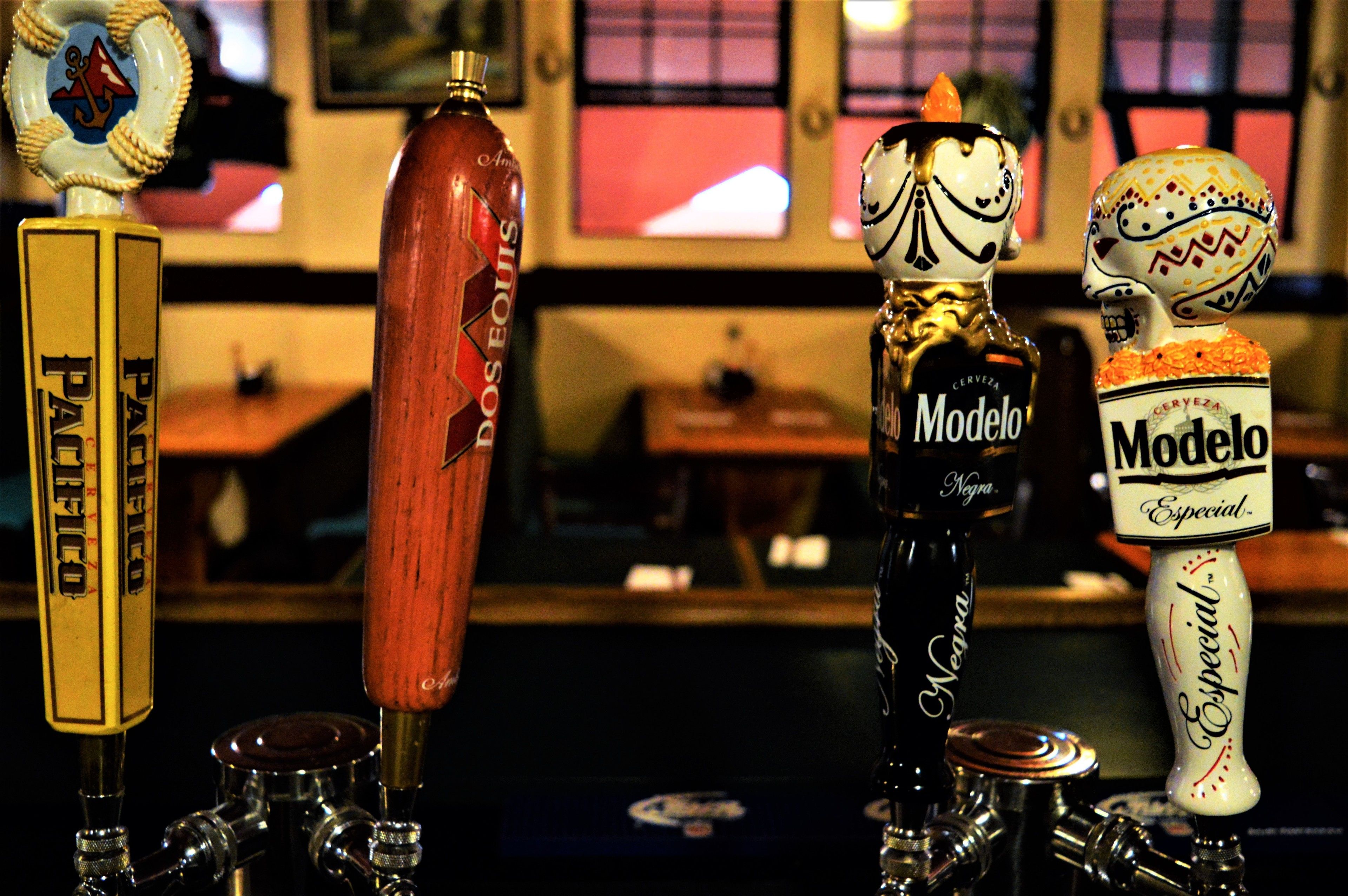 A bar with various beer taps, including brands like Pacifico and Modelo.