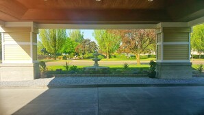 A covered outdoor area with a fountain, surrounded by trees and a well-maintained lawn. - GuestHouse Enumclaw (Enumclaw)