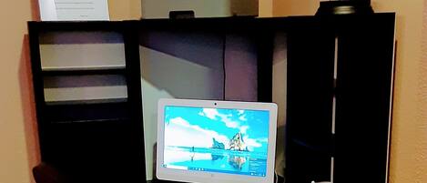 A home office setup with a desktop computer, a printer, and a sign reading "Business Center".
