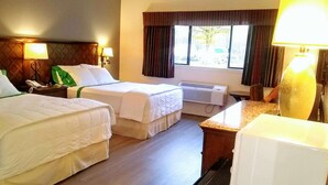 A hotel room with two single beds, a desk, a chair, a telephone, an air conditioning unit, and a window with curtains. - GuestHouse Enumclaw (Enumclaw)