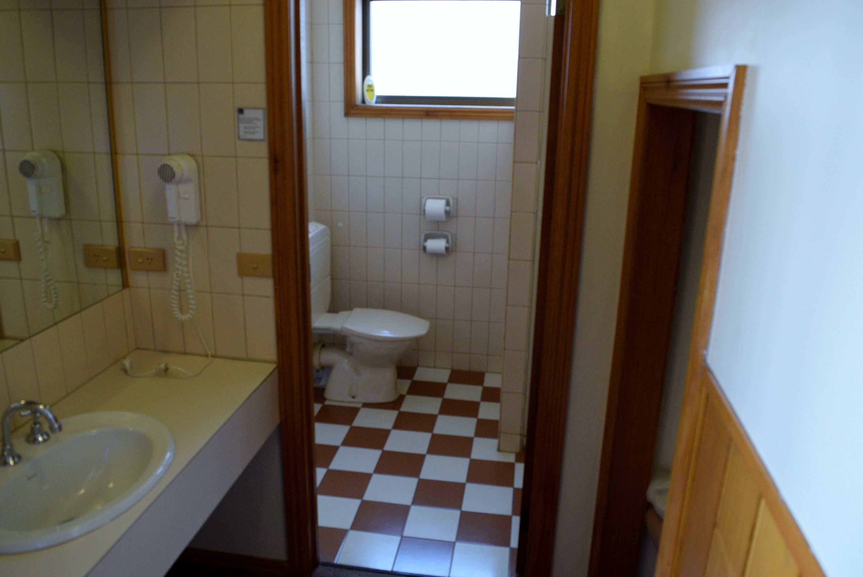 A bathroom with a sink, a toilet, and a mirror.