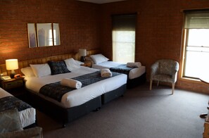 A hotel room with two beds, a chair, and a window. - Bakery Hill Motel (Bakery Hill)