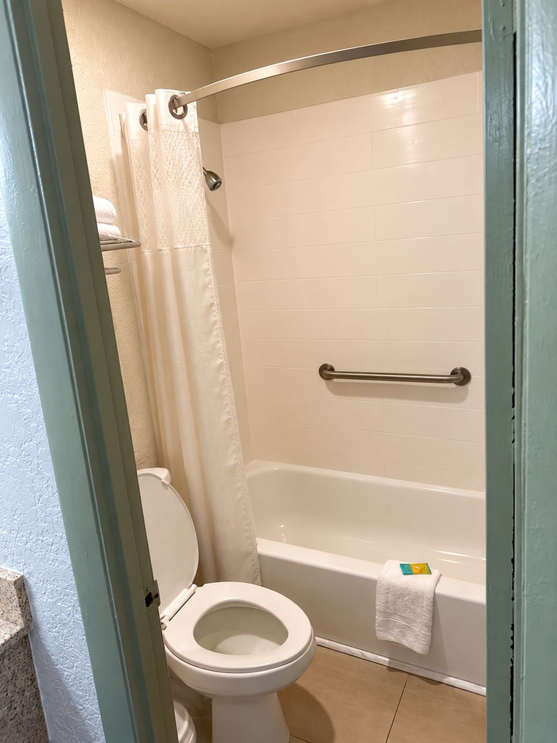 A bathroom with a toilet, a bathtub, and a shower curtain.