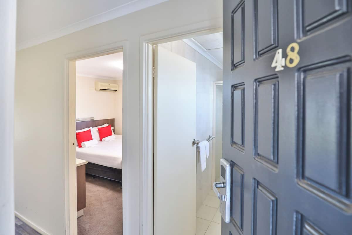 Una habitación de hotel con una cama, una mesita de noche y una puerta con el número 48.