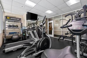 A gym with treadmills, ellipticals, a weight bench, and a wall-mounted TV. - Best Western Vista Inn At The Airport (Boise)