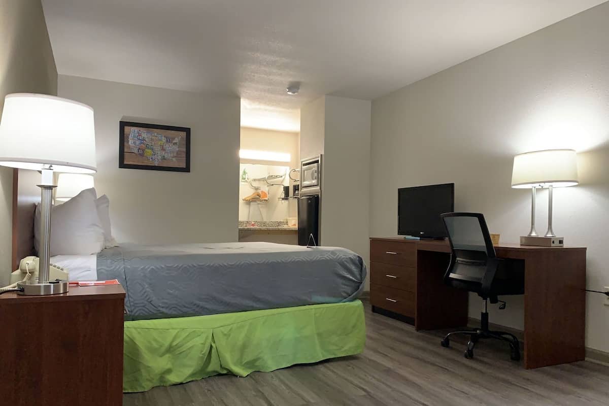 Une chambre d’hôtel équipée d’un lit, d’un bureau, d’une chaise et d’un téléviseur.