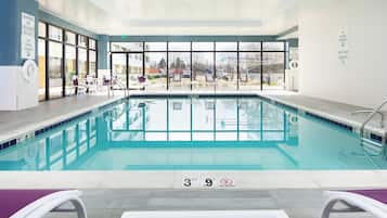 Una piscina techada, sillones reclinables de piscina