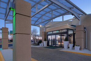 A modern building with a glass entrance, large pillars, and a covered outdoor area. - Holiday Inn Washington-College Pk (I-95) by IHG (College Park)