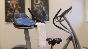 An exercise bike with a digital display and a towel hanging from the handlebars.