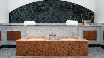 Bathroom features a large, rectangular sink, towel holders, and a curved backsplash.
