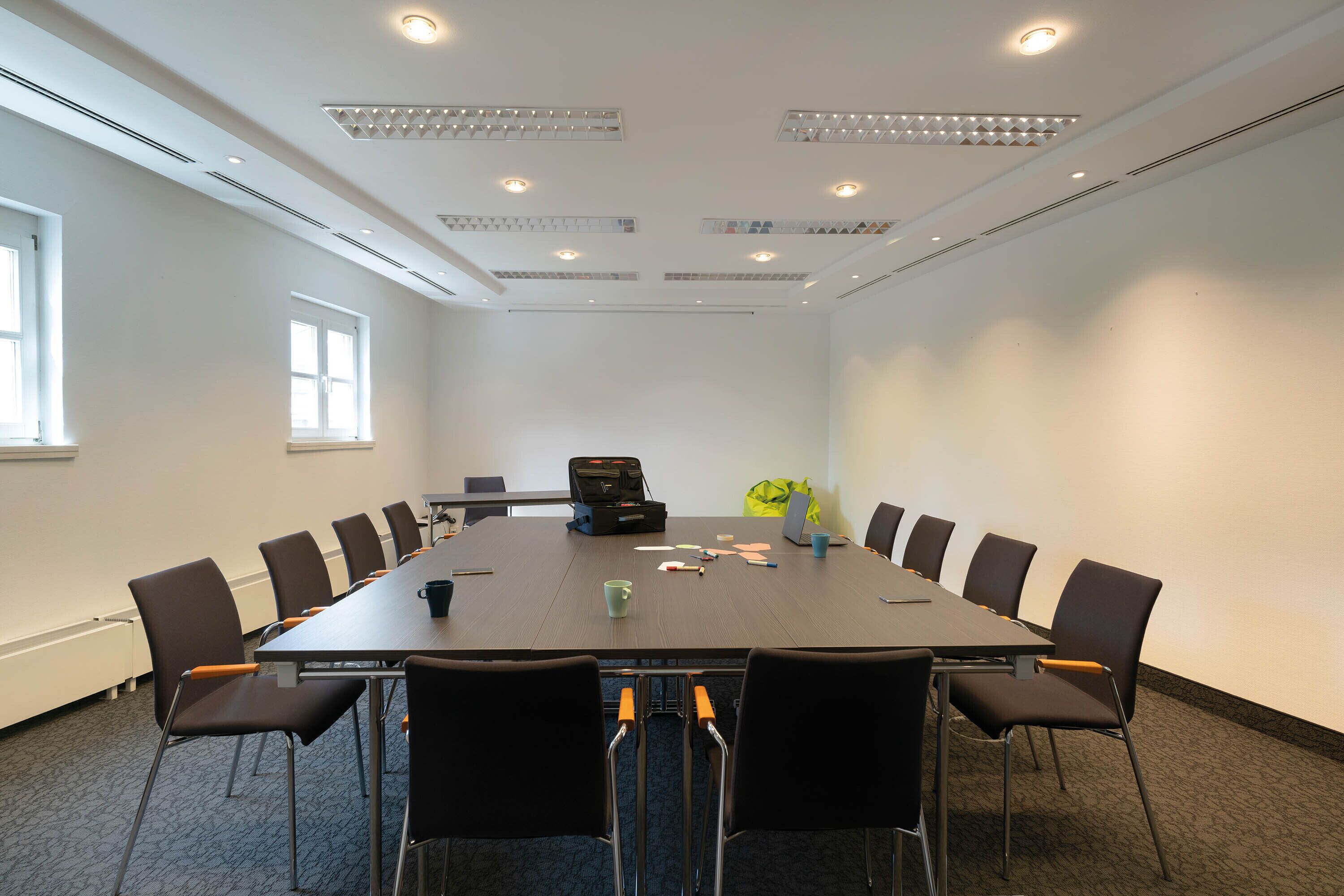 A conference room with a long table, chairs, and a briefcase on the table.