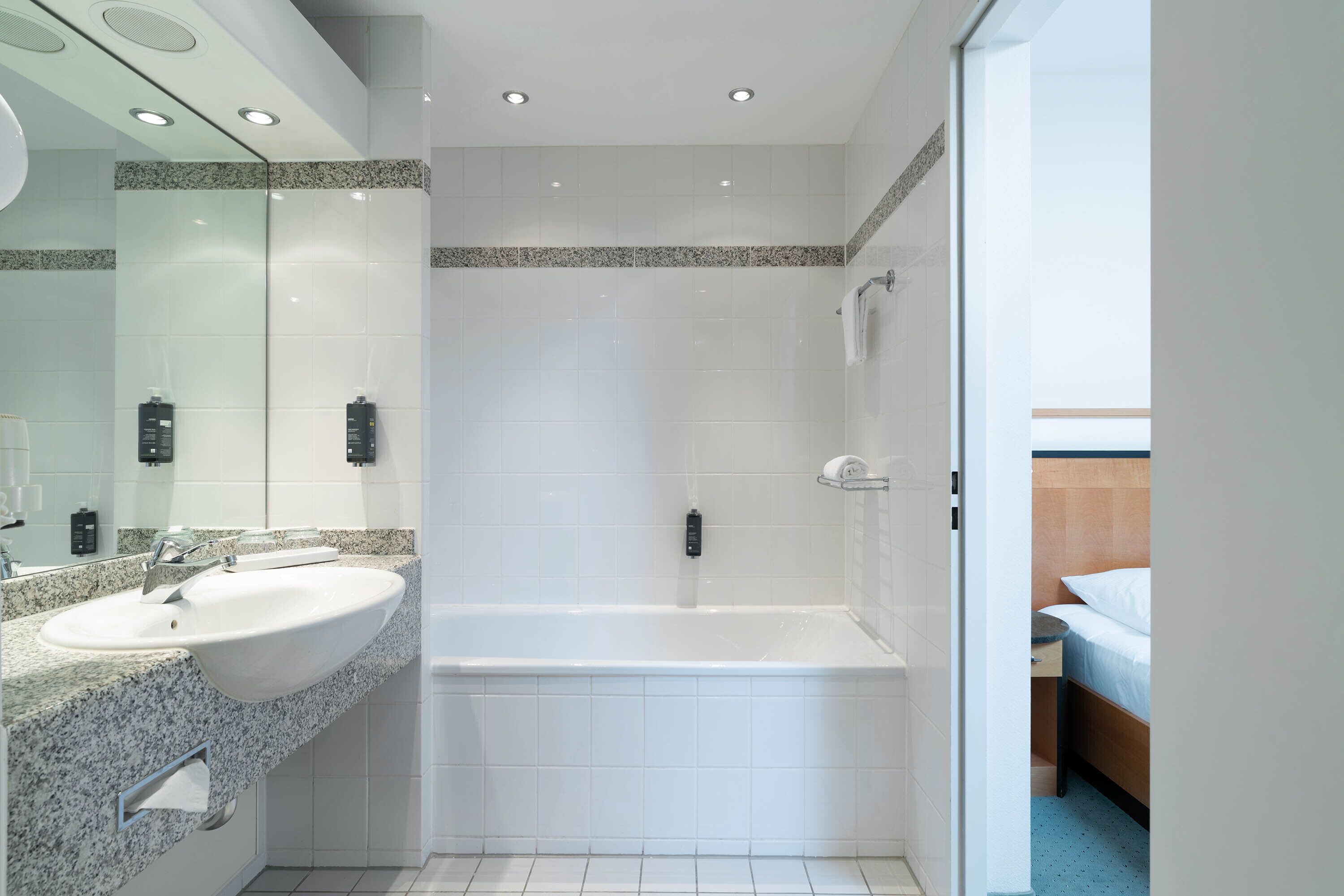 A modern bathroom with a large sink, a bathtub, and a shower.