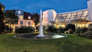 A modern building with a glass facade and a fountain in the courtyard. - Seminaris Hotel Leipzig (Leipzig)