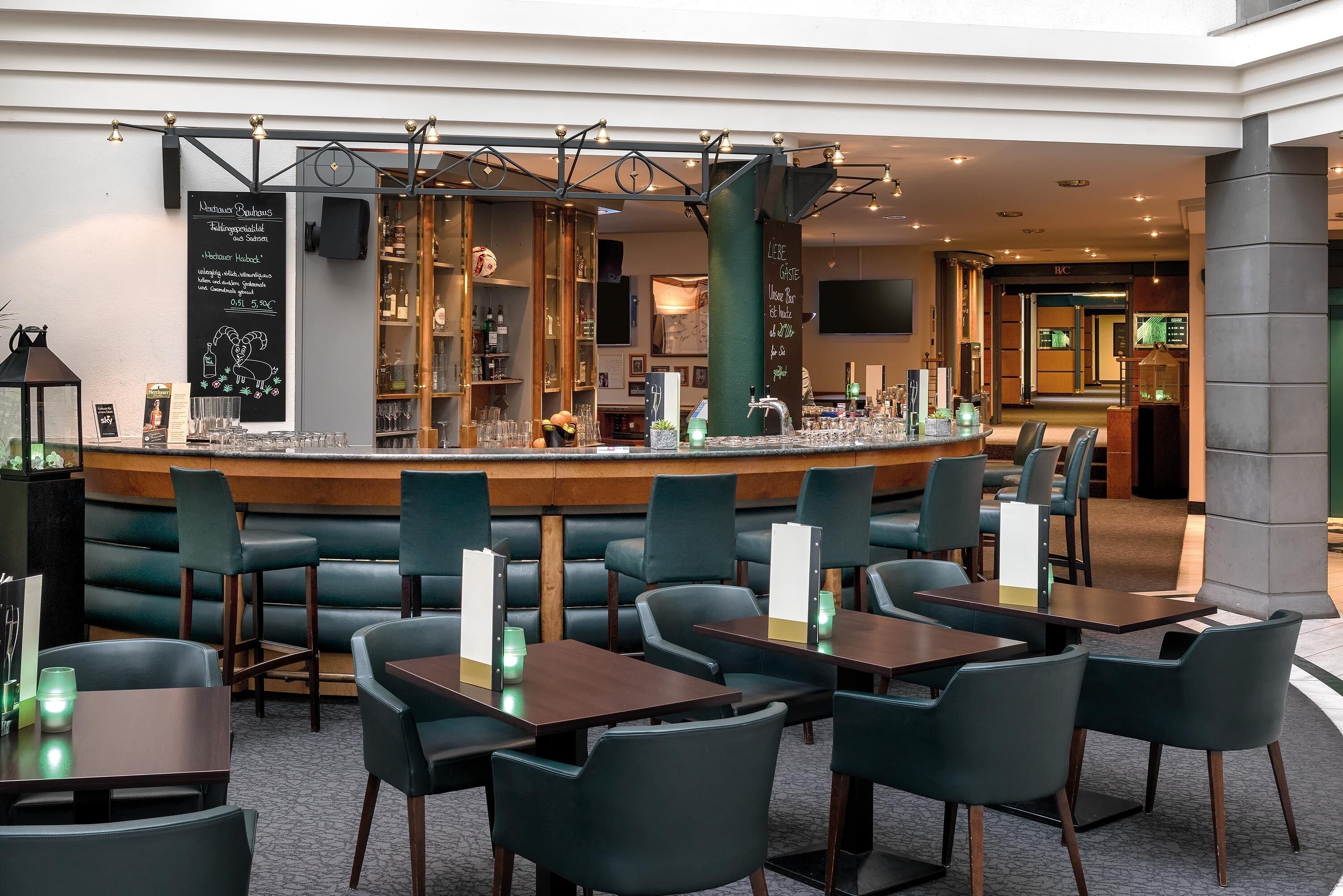 A restaurant with a bar area, booths, and tables.