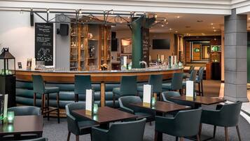 A restaurant with a bar area, booths, and tables.
