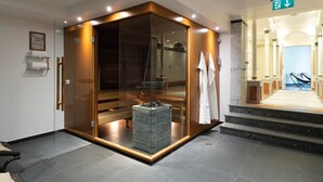 A modern bathroom with a glass-enclosed shower, a marble-tiled floor, and a visible towel rack. - Seminaris Hotel Leipzig (Leipzig)