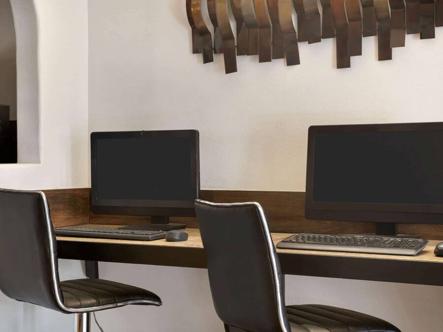 Un espace de bureau moderne comprenant deux bureaux, chacun équipé d’un écran d’ordinateur, d’un clavier et d’une souris.