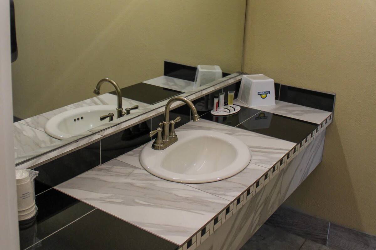 A bathroom with two sinks, a mirror, and a toilet.