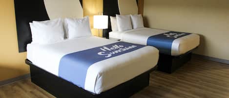 Een hotelkamer met twee bedden, elk met hoofdeinde en nachtkastje.