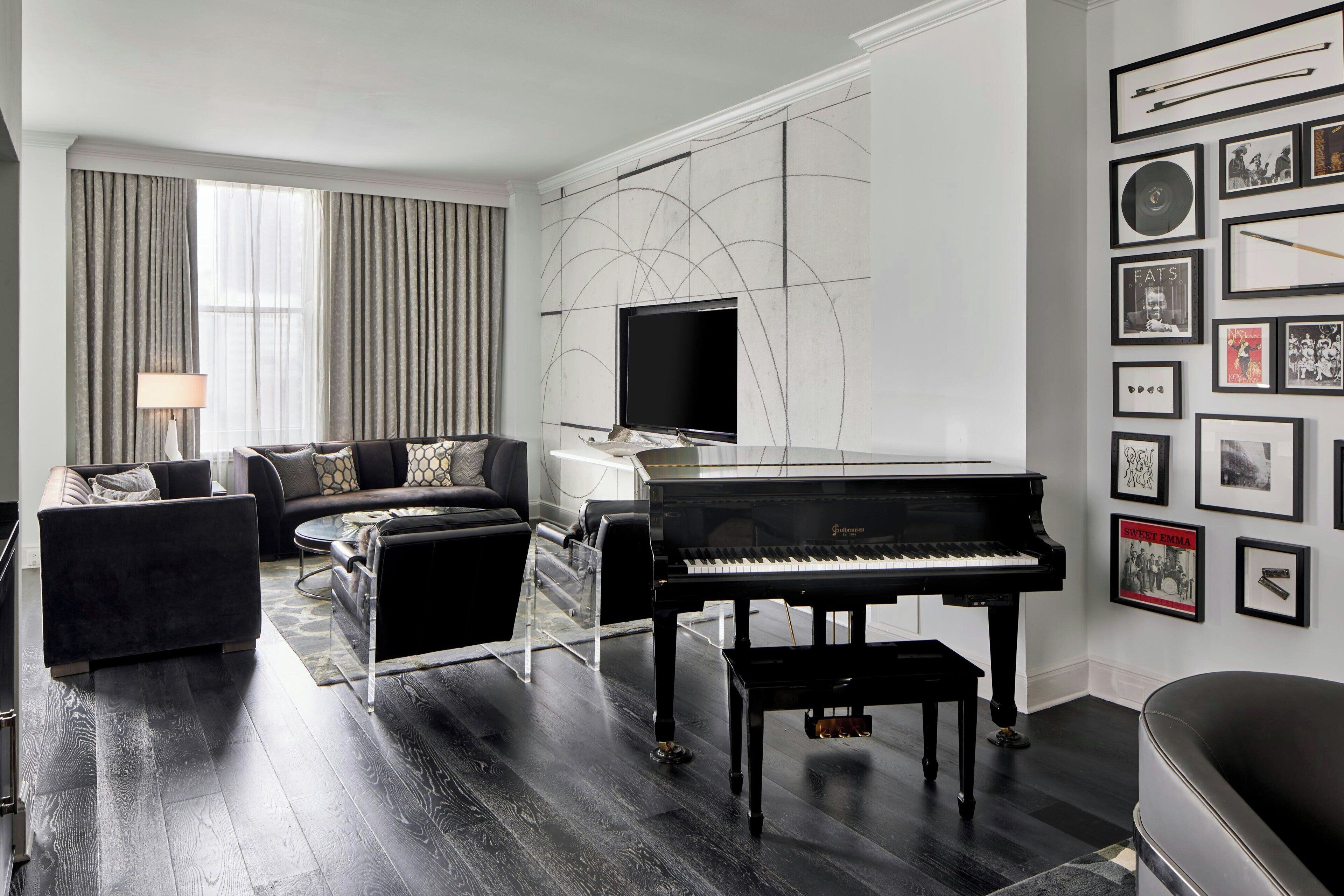 A modern living room with a grand piano, a sofa set, and a flat-screen TV.
