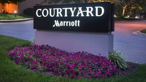 Une enseigne Courtyard Marriott avec un parterre de fleurs devant.