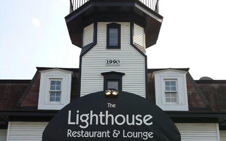 A building with a sign reading 'The Lighthouse Restaurant & Lounge' and a year '1990' on the facade.