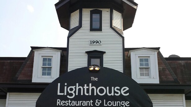 Un bâtiment sur lequel on peut lire l’inscription « The Lighthouse Restaurant & Lounge » et où figure l’année « 1990 » sur la façade.