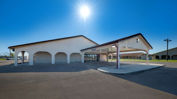 A gas station with a covered parking area and multiple service bays.