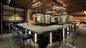 A modern bar area with a central island, bar stools, hanging light fixtures, and a seating area with a cushioned bench. - Courtyard by Marriott Tokyo Ginza Hotel (Tokyo)