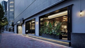 A modern building with large windows, outdoor seating, and a brick facade. - Courtyard by Marriott Tokyo Ginza Hotel (Tokyo)