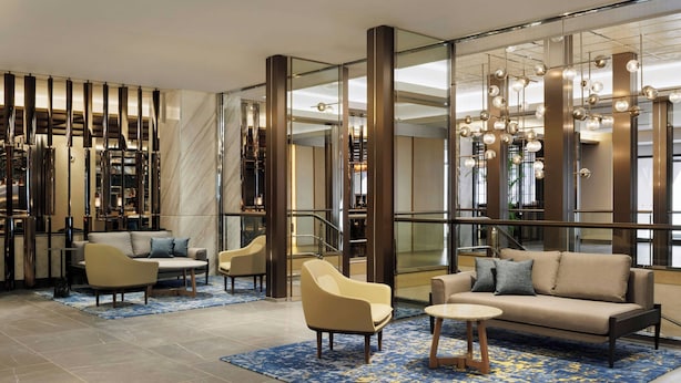 A modern lobby with a sofa, armchairs, a coffee table, and a patterned rug. - Courtyard by Marriott Tokyo Ginza Hotel (Tokyo)