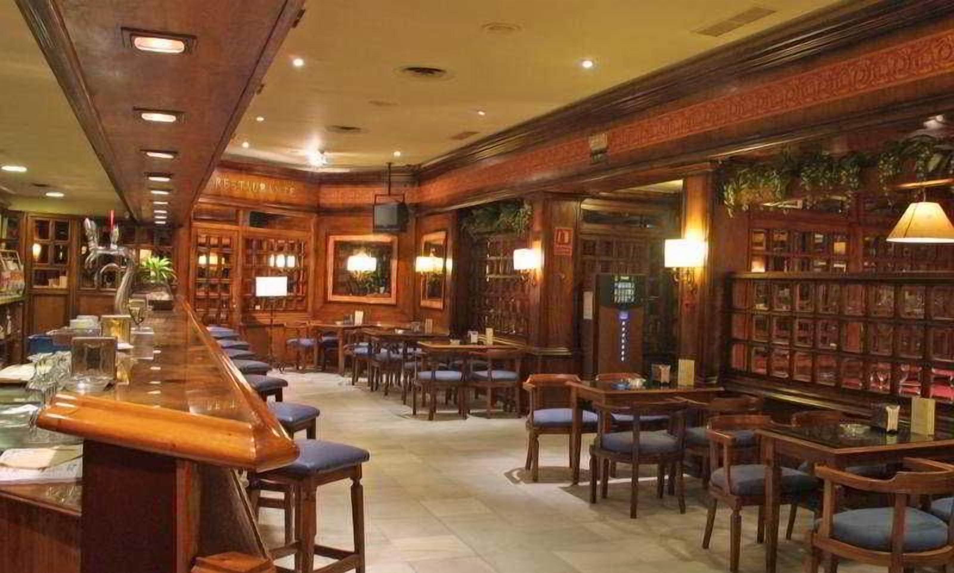 A bar area with wooden furniture, a long counter, and a seating arrangement.