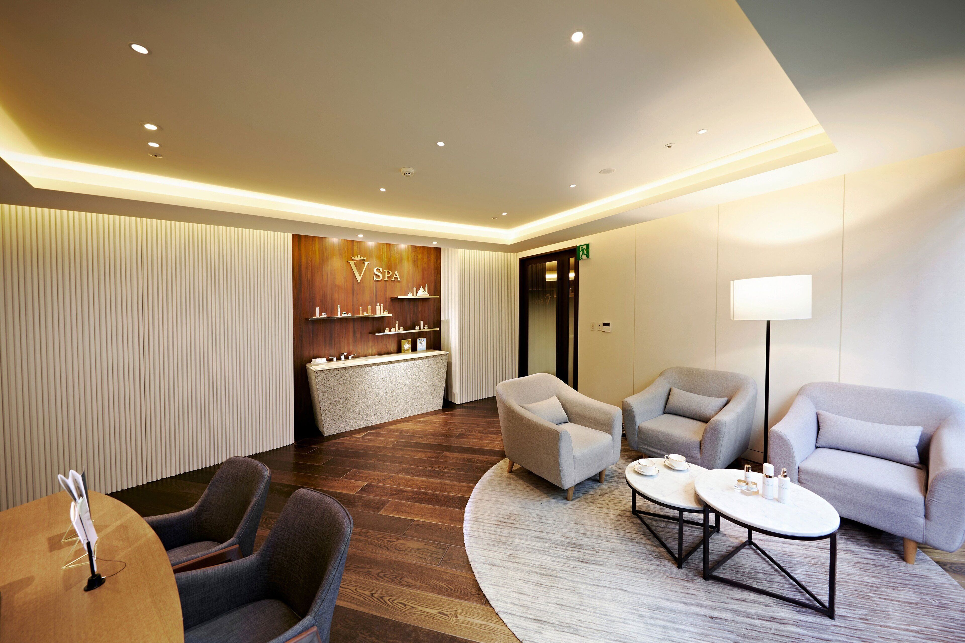 Un hall d’entrée moderne avec un comptoir d’accueil, un espace salon et un panneau indiquant la présence d’un spa.